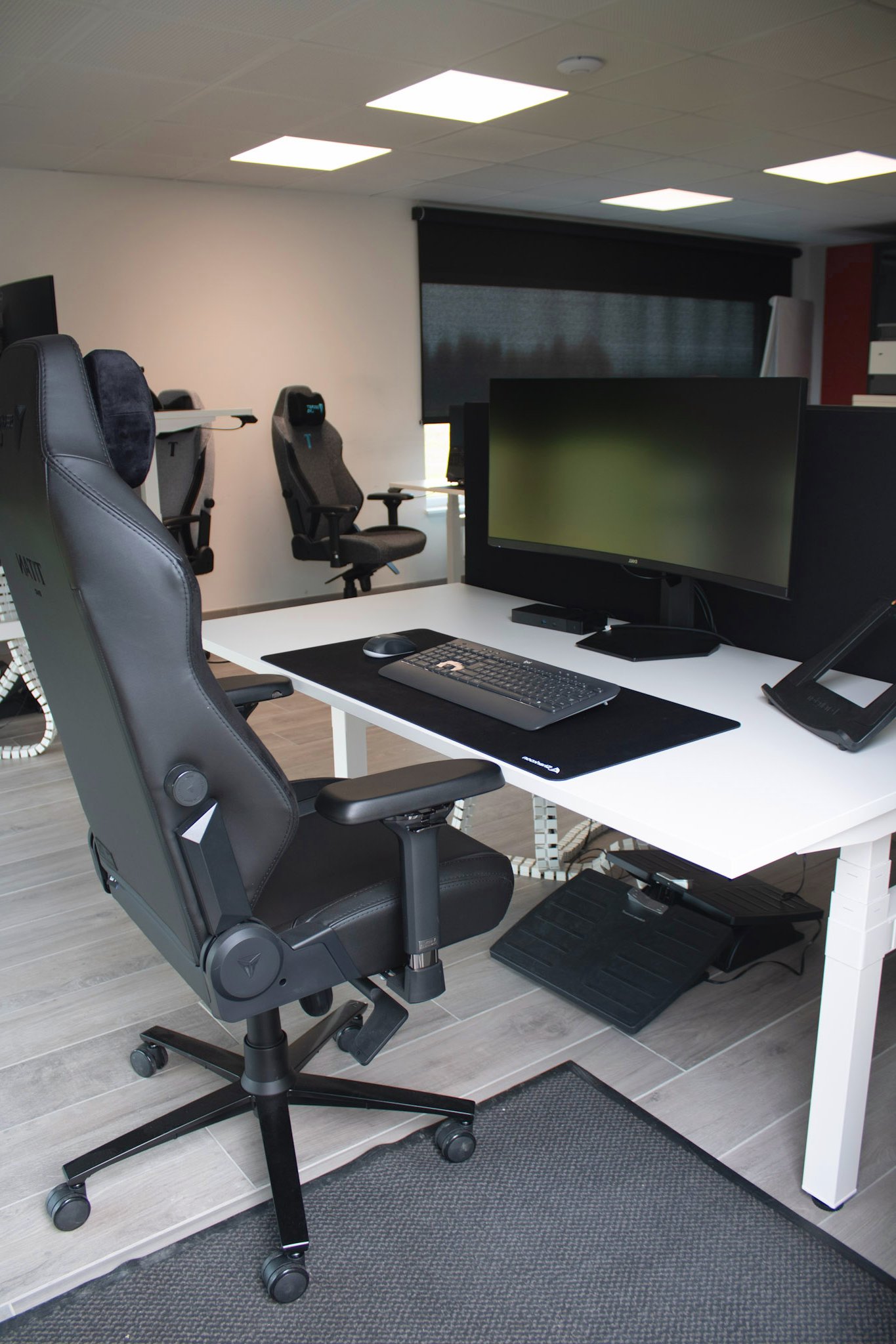 Professioneel ingerichte IT-werkruimte bij Mad IT met dubbele schermen en gaming-stoelen - optimale werkomgeving voor developers en techteams.